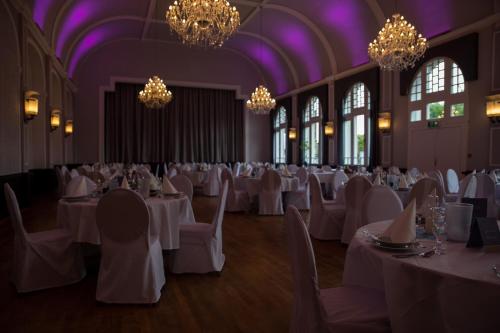 a banquet hall with white tables and chairs and chandeliers at Hotel Tenbrock - Restaurant 1905 in Gescher