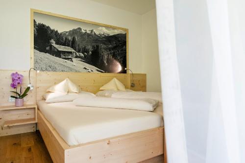 a bedroom with two beds and a picture on the wall at Der Paternwirt in Maria Luggau