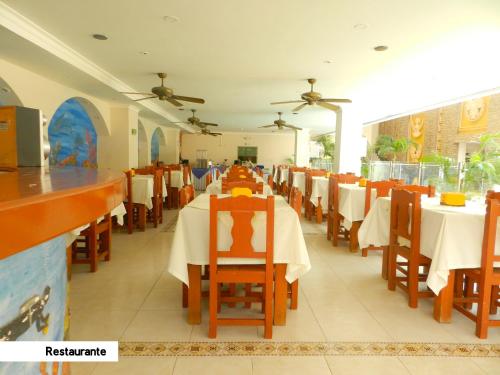 Un comedor con mesas y sillas en un restaurante. en Hotel Tayrona Rodadero, en Santa Marta