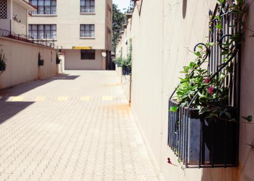 an empty alley with a fence and plants on a building at Fedha Residences by Trianum in Nairobi