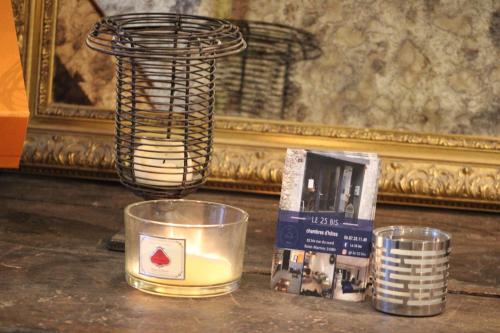 a table with a candle and a lamp and a mirror at le 25bis in Saint-Martory