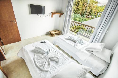 Duas camas num quarto com uma janela em Vila Pérola Negra em Itacaré