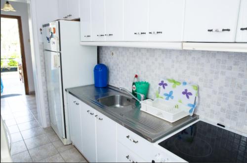 a kitchen counter with a sink and a refrigerator at Villa Pleiades #1 in Nea Vrasna