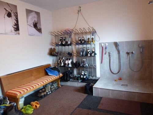 baño con ducha y banco en una habitación en Alpina Appartements, en Haldensee