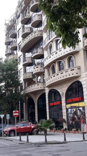 a large building with cars parked in front of it at Apartament in the centre batumi in Batumi