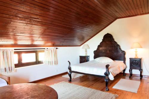 セジンブラにあるAkivillas Sesimbra Teltaleの木製の天井が特徴のベッドルーム1室(ベッド1台付)