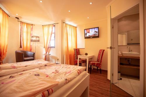 ein Hotelzimmer mit einem Bett und einem Waschbecken in der Unterkunft Hotel Mosella in Bullay