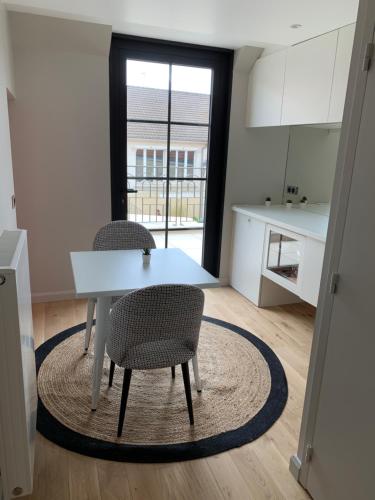 a kitchen with a table and two chairs in a room at L'appartement et les Suites de VJL... in Avize