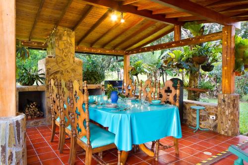einen blauen Tisch und Stühle unter einer hölzernen Pergola in der Unterkunft La Casa de Piedra in Guatapé