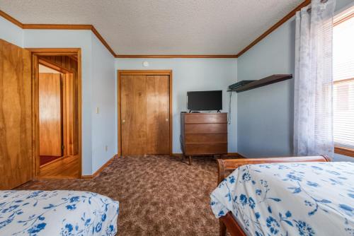 a bedroom with two beds and a tv and a dresser at Nautical North in Ocean City