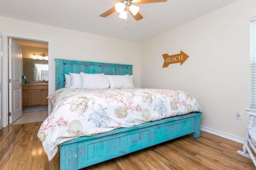 un letto blu in una camera da letto con ventilatore a soffitto di Rockport Getaway a Rockport
