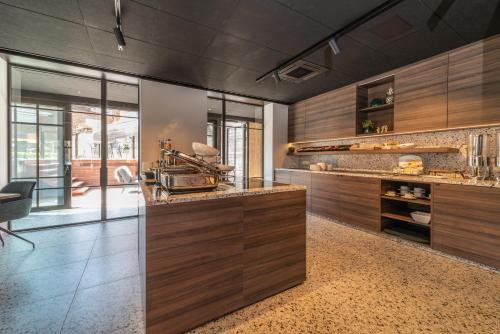a kitchen with wooden cabinets and a counter top at Hotel Cajou in De Panne