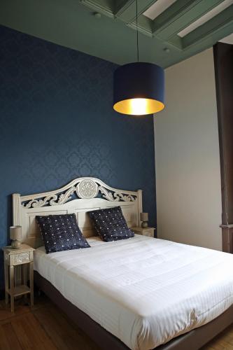 une chambre avec un lit blanc avec un mur bleu dans l'établissement Le Clos Renaissance, à Amboise