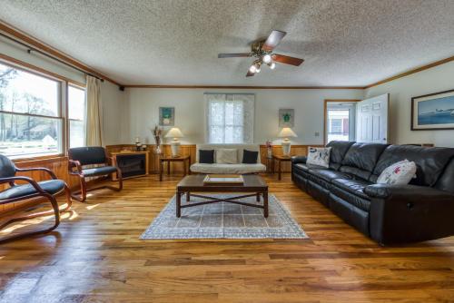 a living room with a black leather couch and a table at Nautical North in Ocean City