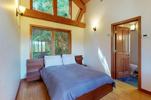1 dormitorio con 1 cama en una habitación con ventanas en Woodland Hideaway in the Hills en Lake Stevens