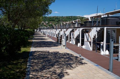 a row of houses on a sidewalk next to trees at Floating House Marina Royal in Portorož