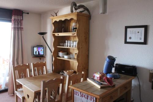 een eetkamer met een tafel en een houten tafel en stoelen bij Les Eglantines A in Bolquere Pyrenees 2000