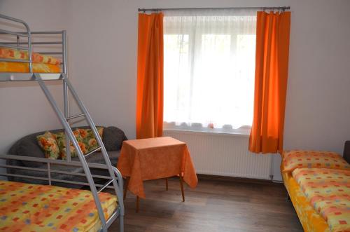 a bedroom with a bunk bed and a window with orange curtains at Chalupa Bohunka in Bouzov