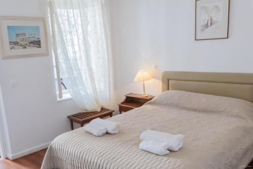 a bedroom with a bed with two towels on it at Hotel Miranda in Hydra