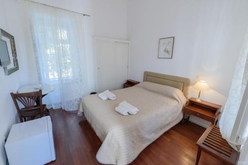 a bedroom with a bed with two towels on it at Hotel Miranda in Hydra