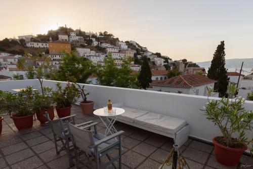 a patio with a table and chairs on a balcony at Hotel Miranda in Hydra