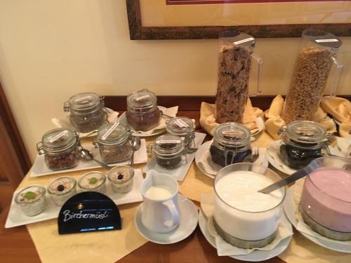 a table topped with dishes and jars of food at Genießerhof Haimer - Hotel Garni in Poysdorf
