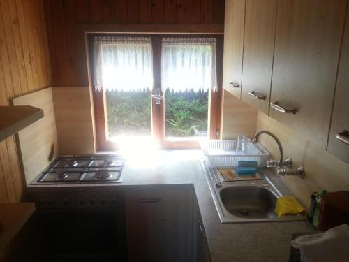 a kitchen with a stove and a sink and a window at Ferienhütte Rist in Kaltenbach