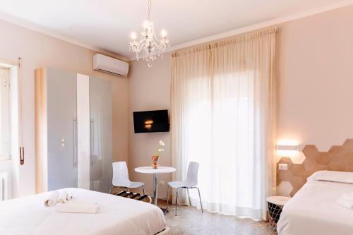 sypialnia z 2 łóżkami, stołem i żyrandolem w obiekcie Roma Talenti Fucini B&B w Rzymie