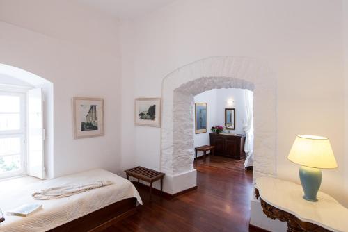 a room with two beds and a stone archway at Hotel Miranda in Hydra