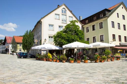 a cobblestone street in a town with white umbrellas at Hotel Drei König in Immenstadt im Allgäu