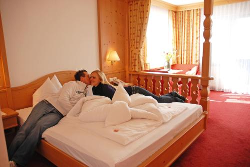 a woman laying on top of a bed in a hotel room at Hotel Heinz in Brunico