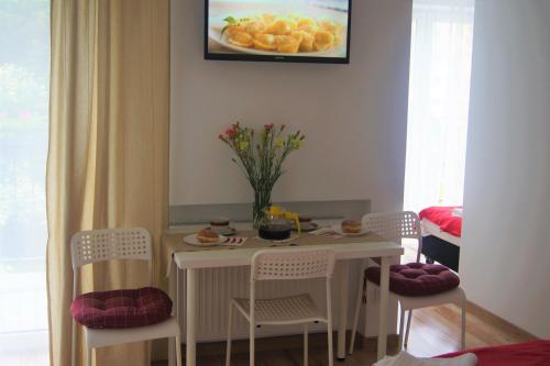 a dining room table with chairs and a table with fruit on it at Willa Wena in Ustka