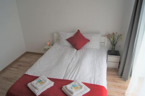 a bedroom with a white bed with red and white pillows at Willa Wena in Ustka