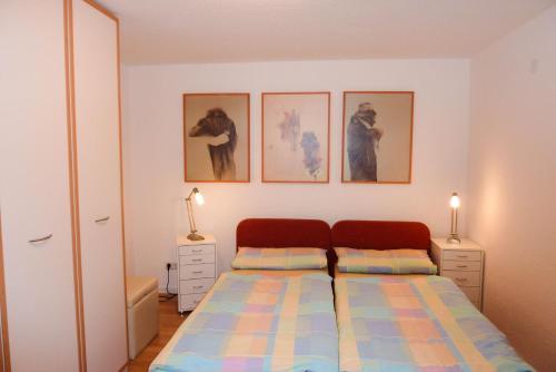 a bedroom with a bed and three pictures on the wall at Ferienwohnung Marienblick in Sipplingen