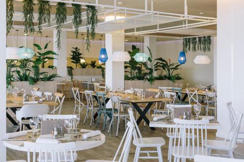 a restaurant with tables and chairs and plants at Alua Village Fuerteventura - All Inclusive in Playa Jandia