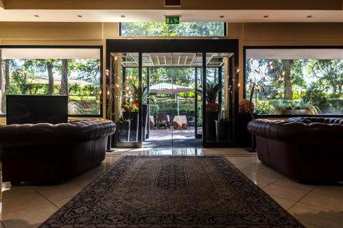 a lobby with two leather couches and a television at Hotel Terme Salvarola in Sassuolo
