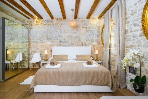 a bedroom with a bed and a stone wall at LUX AURELIUS in Split Centre Old Town in Split