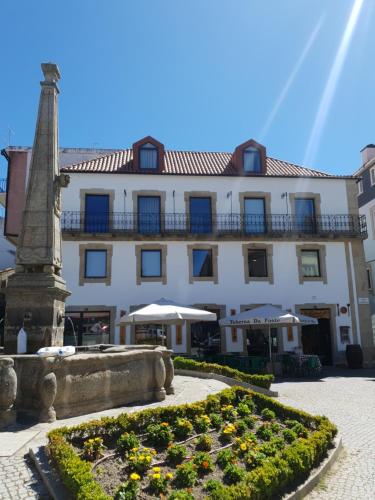 un bâtiment avec un monument en face d'un jardin dans l'établissement Alojamento 4 Bicas, à Seia