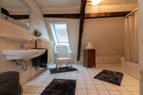 a bathroom with a sink and a chair in it at Ferienwohnung Flämisches Weinhaus in Wintrich