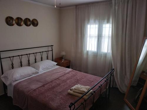 a bedroom with a large bed and a window at Near Airport And metropolitan Artemis George Cozy Home in Artemida