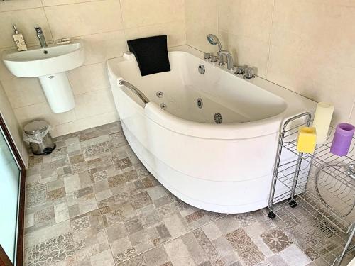 a bath tub and a sink in a bathroom at Penthouse Apartment 401 in Tbilisi City