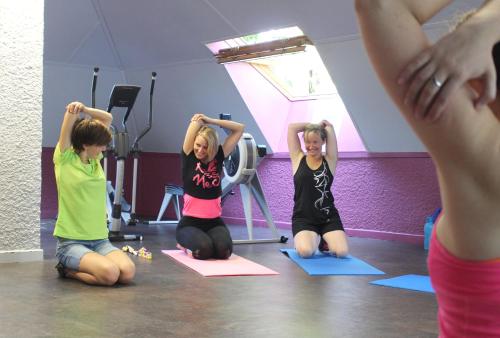 three women sitting on mats in a yoga class at VVF Bourgogne Auxois Morvan in Semur-en-Auxois