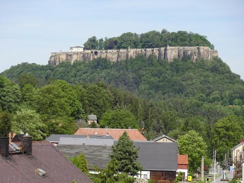 a castle on top of a mountain with houses at Ferienhaus am Malerweg in Königstein an der Elbe