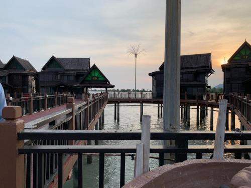 a group of buildings on a pier with water at Langkawi Lagoon Resort Water Chalet in Pantai Cenang