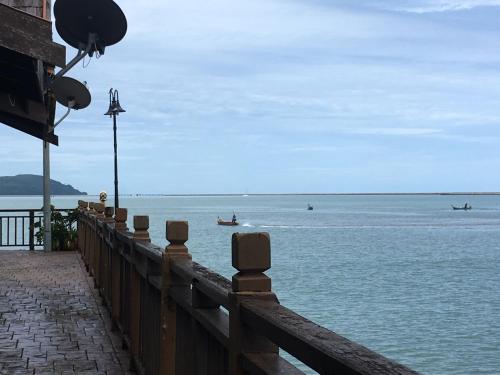 a wooden fence next to a body of water at Langkawi Lagoon Resort Water Chalet in Pantai Cenang