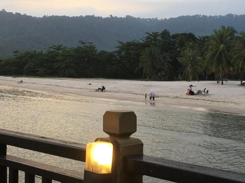 a light on a fence next to a beach at Langkawi Lagoon Resort Water Chalet in Pantai Cenang