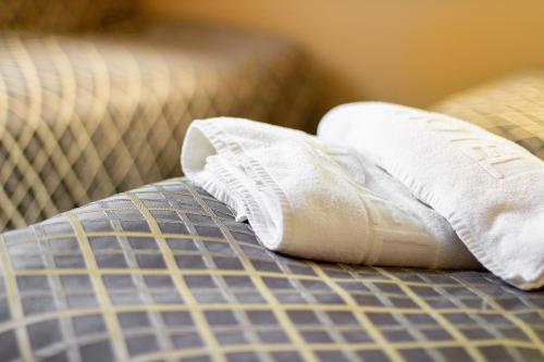 a pair of rolled up towels on a bed at Willa Kłodzko-Zacisze - sauna, siłownia, komnata solna, parking in Kłodzko
