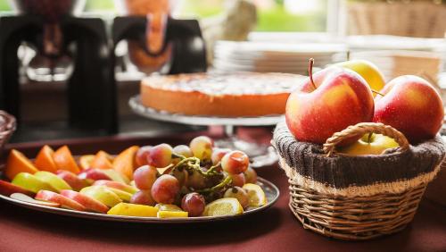a table with a plate of apples and a basket of fruit at Willa Kłodzko-Zacisze - sauna, siłownia, komnata solna, parking in Kłodzko