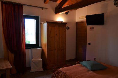 a bedroom with a bed and a window at Agriturismo Le oche selvatiche in Lauzacco