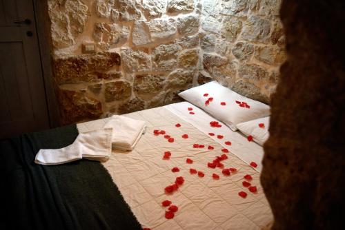 a bed with red flowers on it in a room at Dimore Storiche - Ulivo di Aldo in Martina Franca